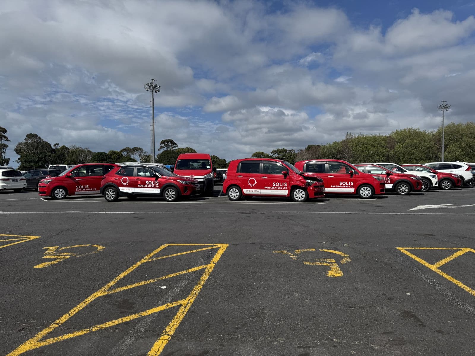 Solis Panelbeaters branded courtesy car fleet lined up in a car park