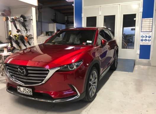 Finished glossy red Mazda CX-9 after repair