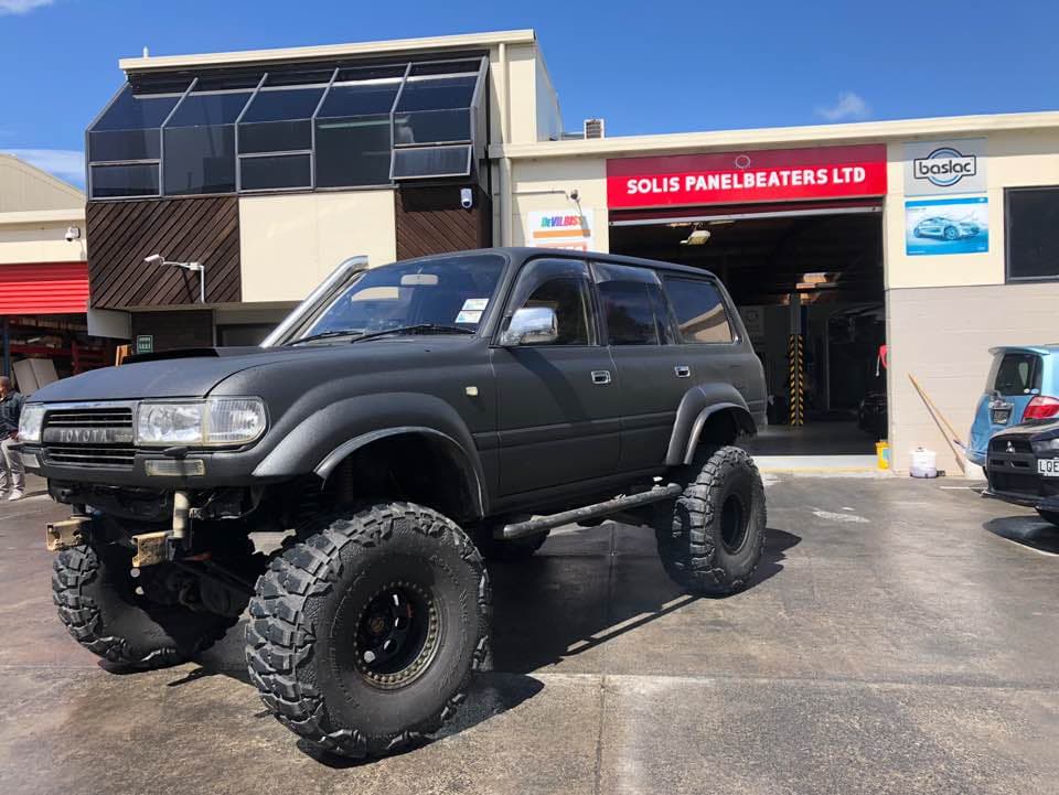 Custom matte black lifted Toyota Land Cruiser outside the Solis workshop