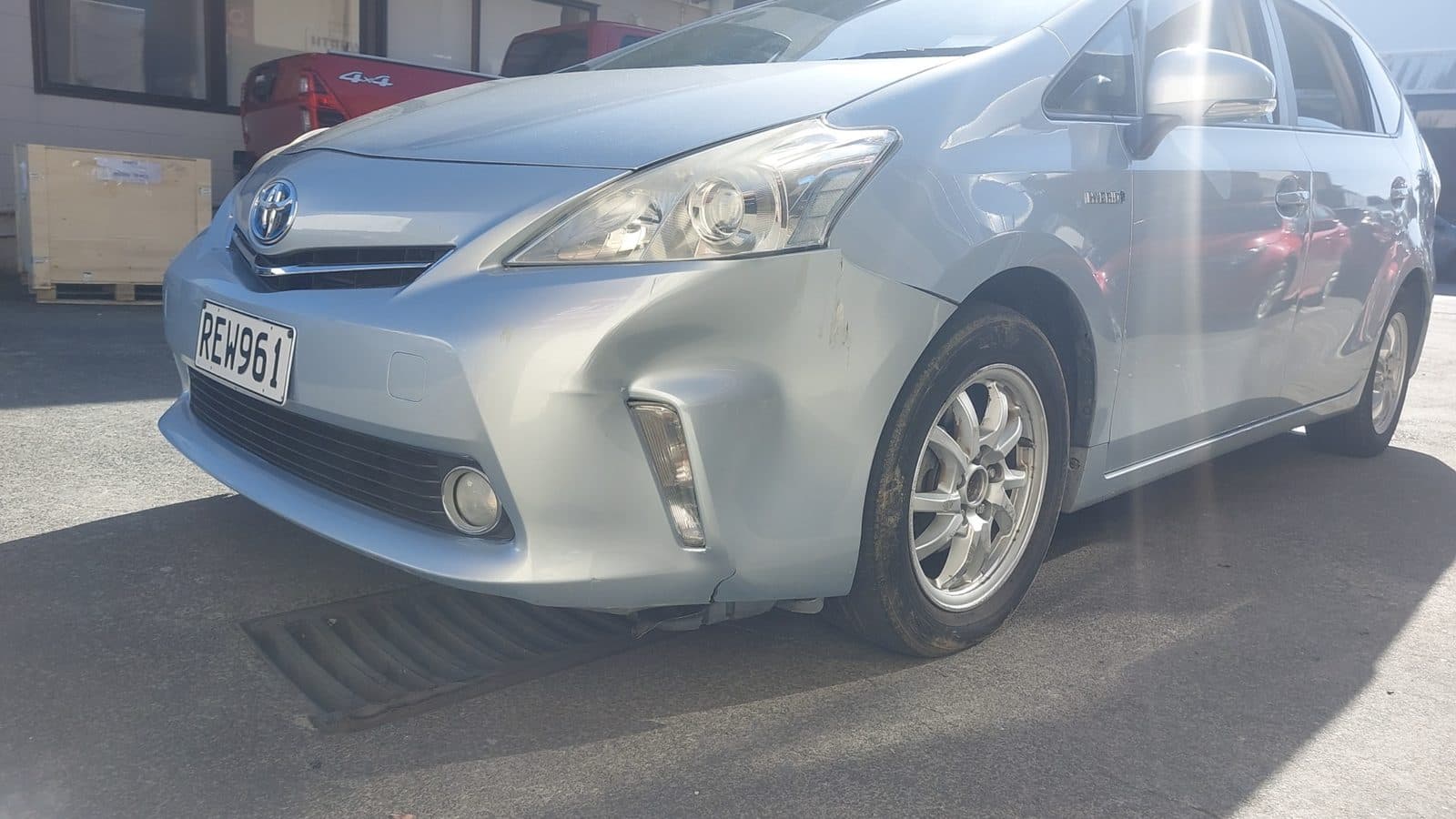 수리 전 앞 범퍼와 펜더가 손상된 하늘색 Toyota Prius V