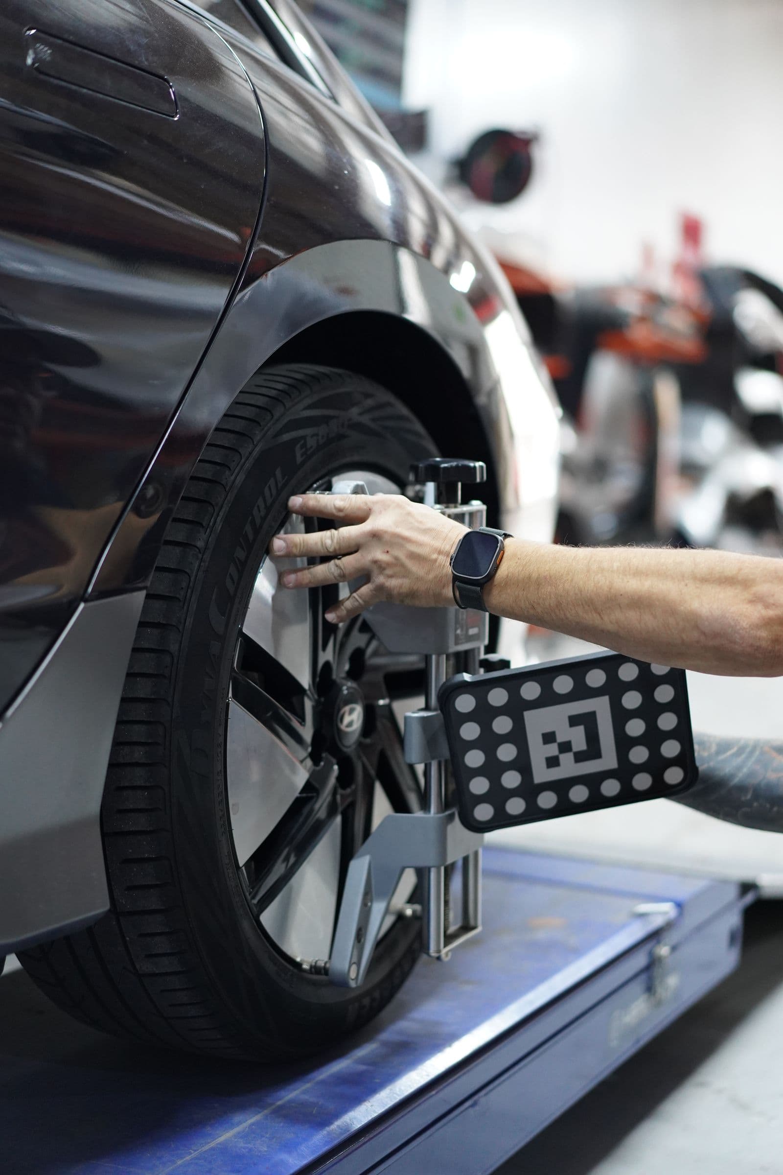 Wheel alignment target clamped to a wheel at Solis Panelbeaters